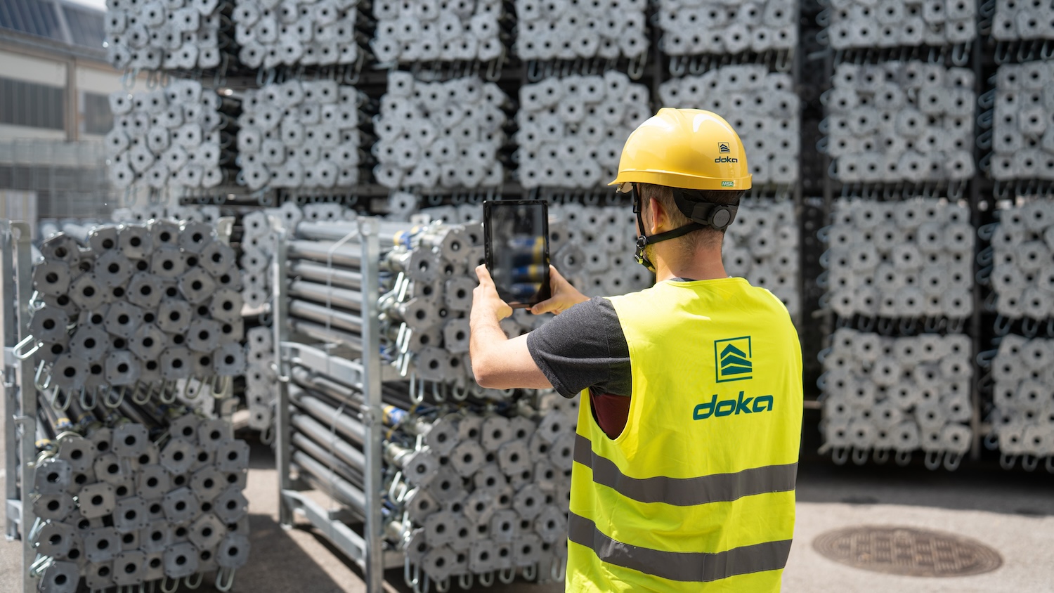 Doka worker using AI counting technology to count formwork and scaffolding in a Doka yard